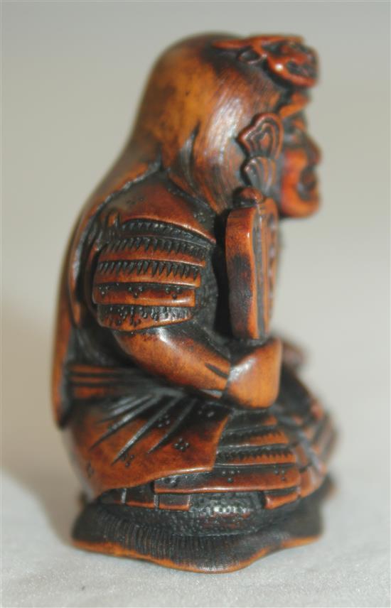 A Japanese boxwood netsuke of a seated Samurai General, late 19th century, 4.5cm